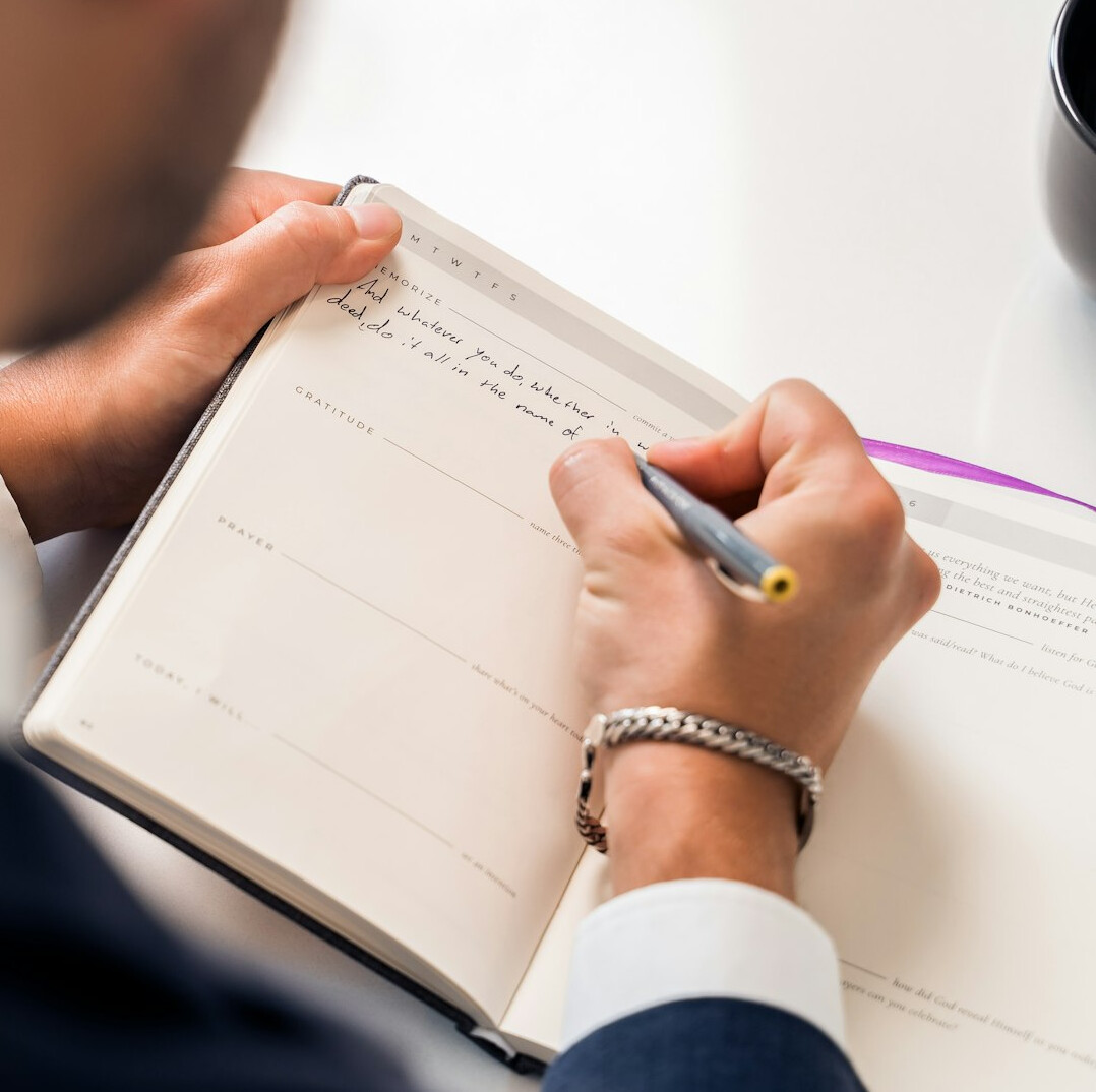man writing in notebook